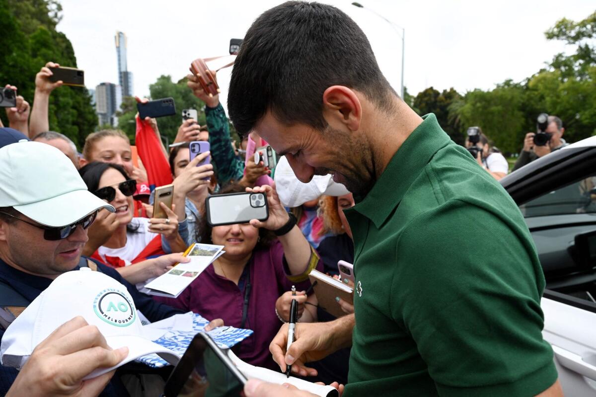 Novak Djokovic signs autographs to his supporters outside the Government House  in Melbourne. — AFP