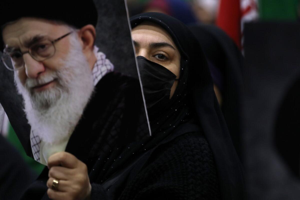 An Iranian woman holds a poster of the Supreme Leader Ayatollah Ali Khamenei during an election campaign rally ahead of the March 1. — AP