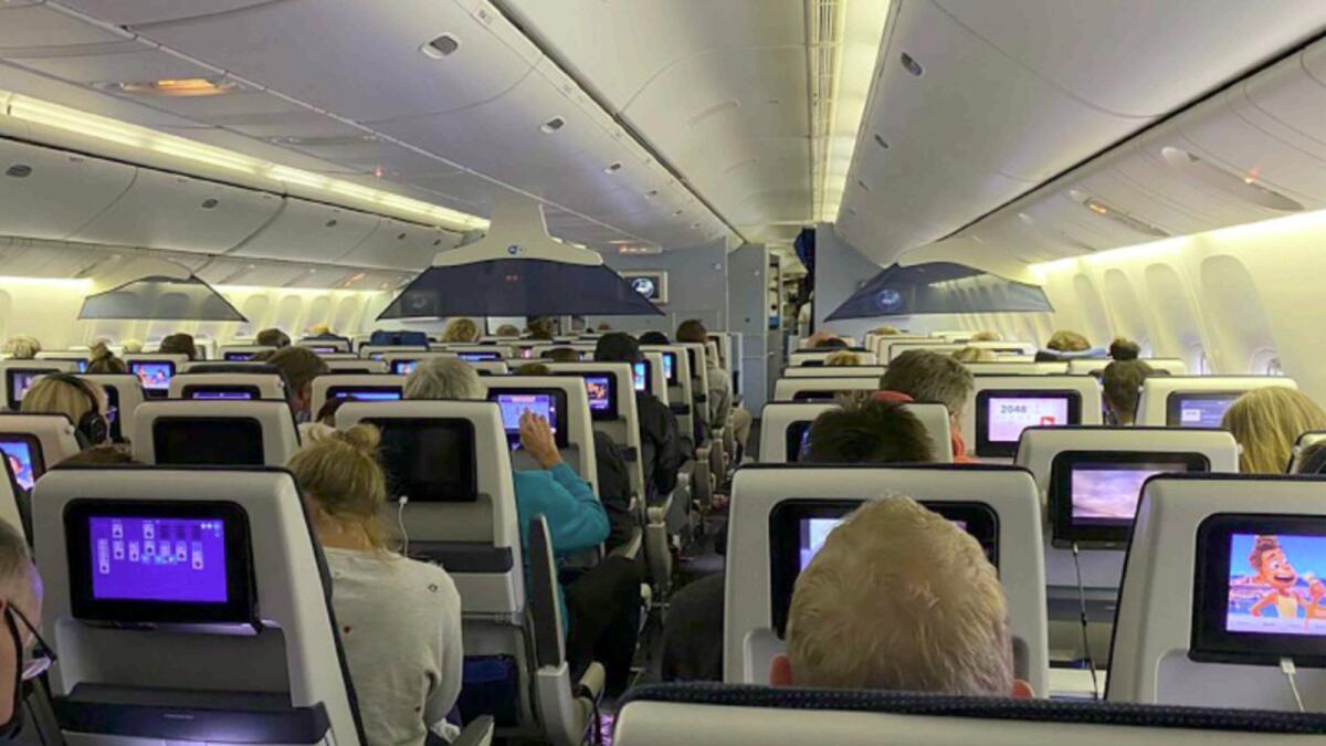 Passengers sit in their seats aboard KLM Flight 598 on the tarmac at Schipol airport in Amsterdam after it landed from Cape Town. — AP