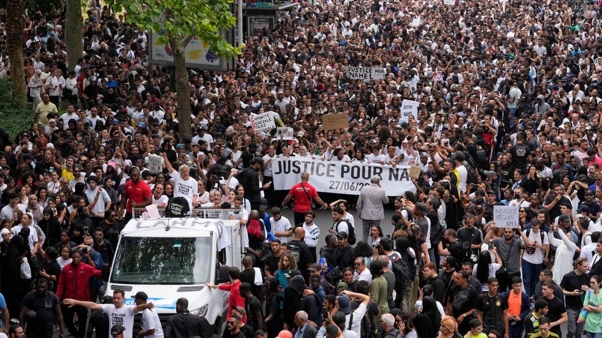 The mother of killed 17-year-old Nahel, at left on truck, gestures during a march in Nanterre, outside Paris. - AP