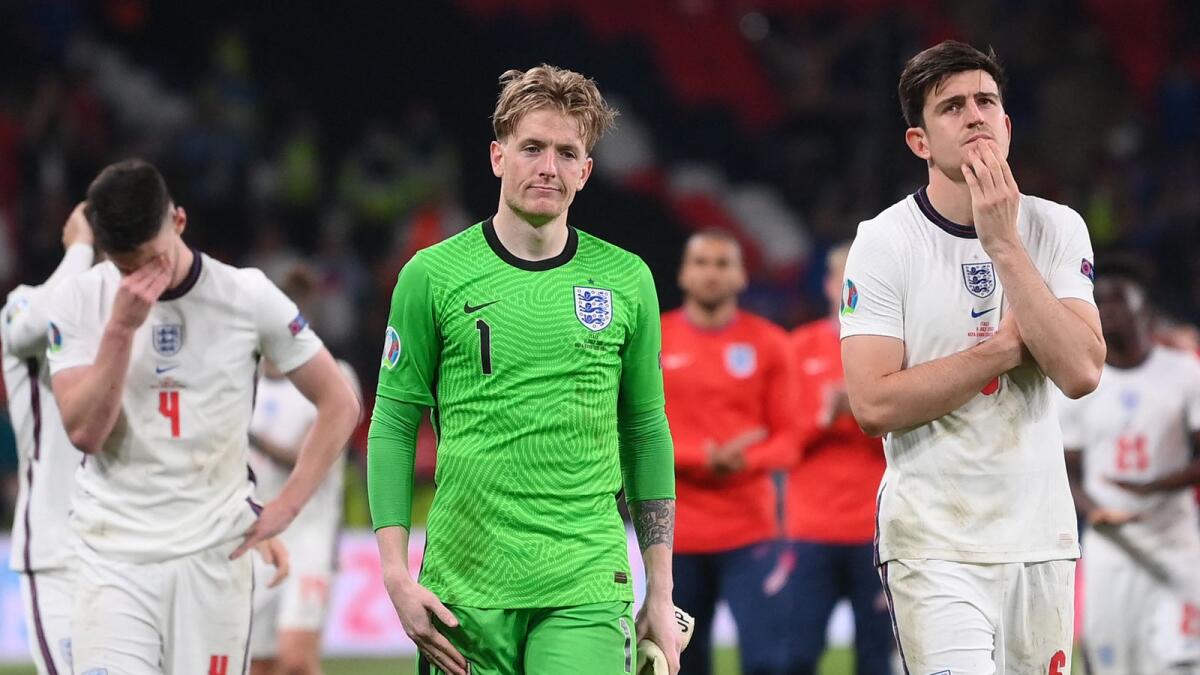 England goalkeeper Jordan Pickford and defender Harry Maguire (right) react after their defeat to Italy in the Euro 2020 final. (AFP)
