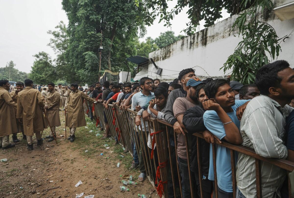Police personnel stand guard as people line up to buy tickets for the third Twenty20 cricket match between India and Australia at Gymkhana grounds in Hyderabad, India, Thursday, Sept. 22, 2022. Photo: AP