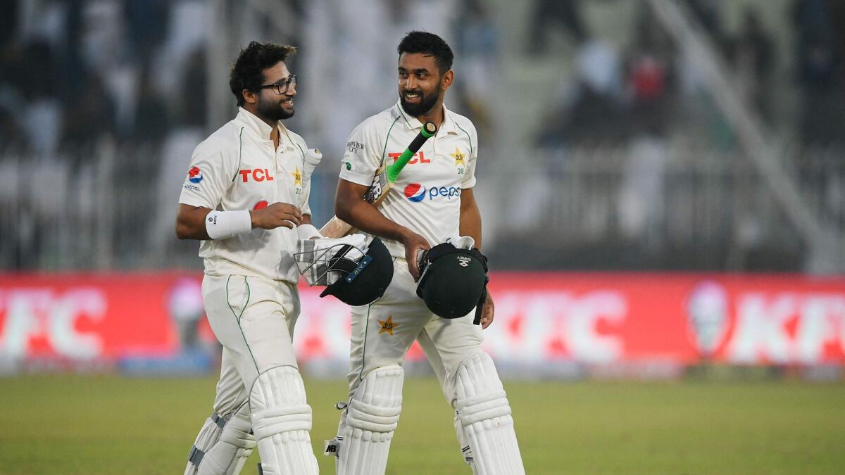 Pakistan's Abdullah Shafique (right) and teammate Imam-ul-Haq walk back to the pavilion at the end of the  second day of the first Test against England at the Rawalpindi Cricket Stadium on Friday. — AFP