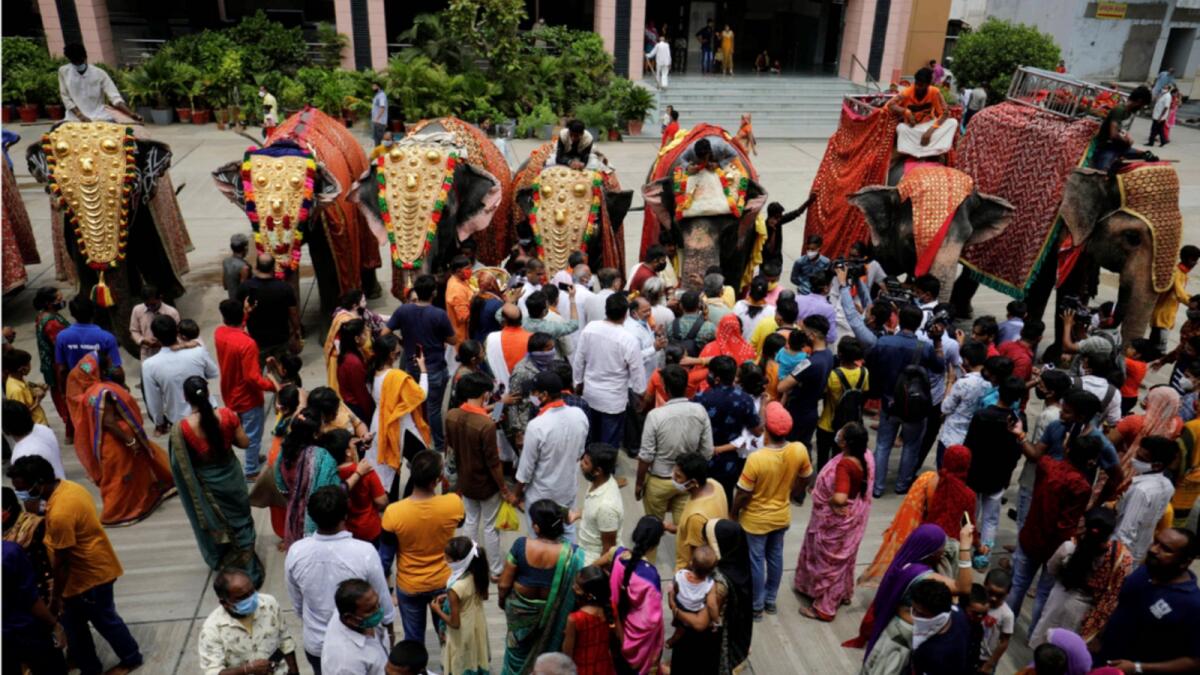Hindu devotees gather next to decorated elephants inside a temple in Ahmedabad on the eve of the annual Rath Yatra. — Reuters