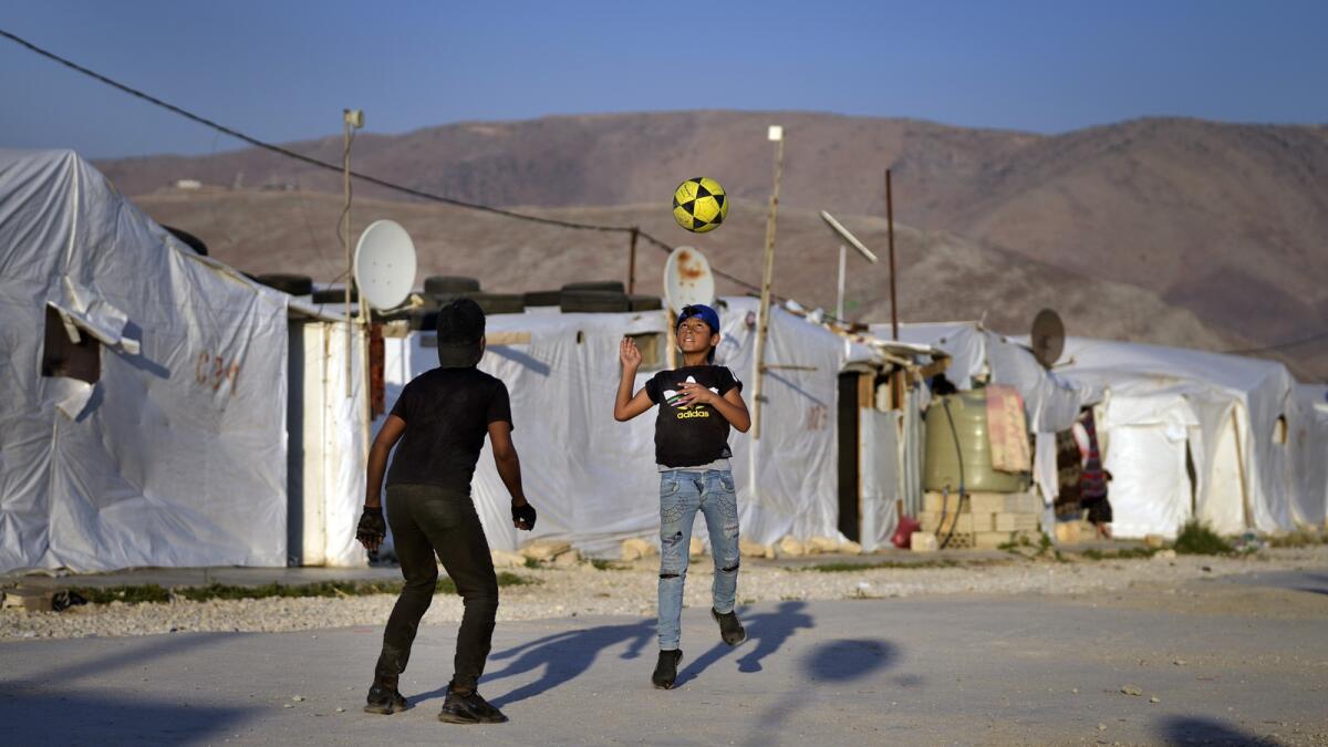 Syrian children play soccer near their tented homes at a refugee camp in the town of Bar Elias, in the Bekaa Valley, Lebanon. — AP file