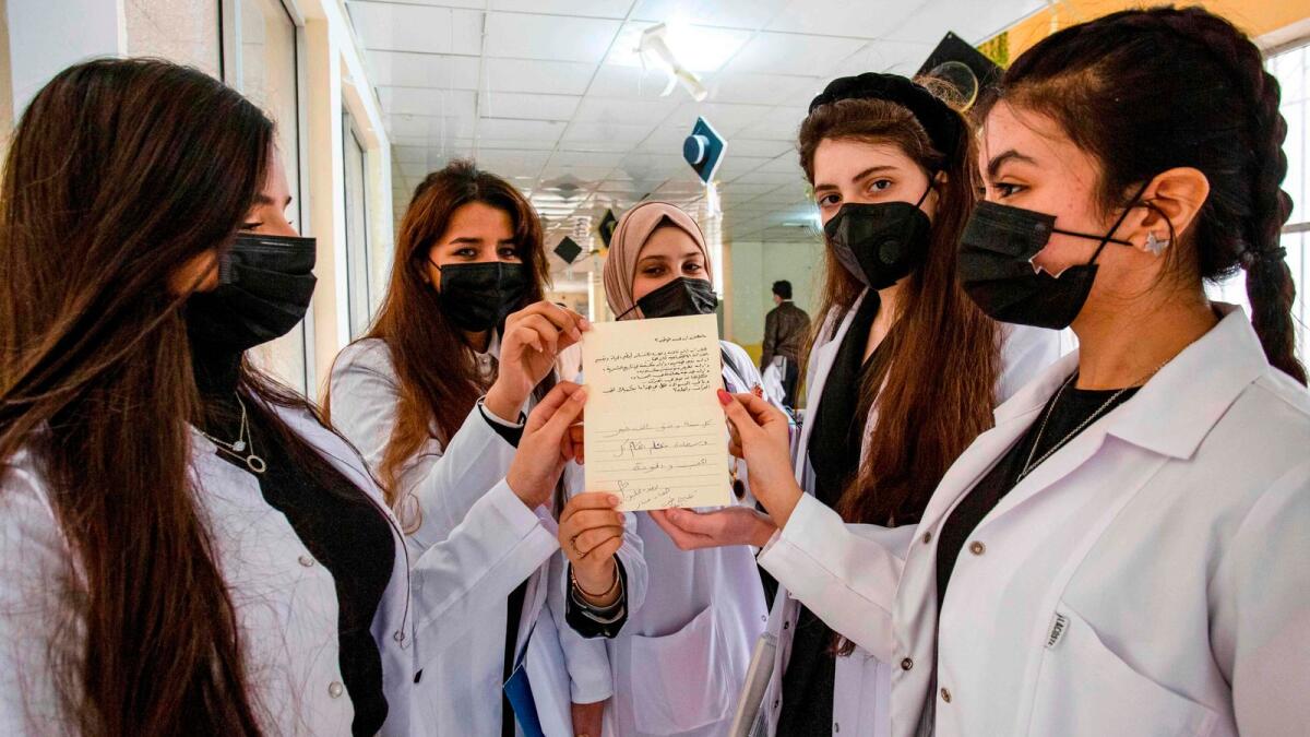 Medical students present a signed personalised Christmas greeting card in Iraq's southern city of Basra on December 23, 2020, to be delivered on Christmas Eve to residents of the northern Christian town of Qaraqosh.