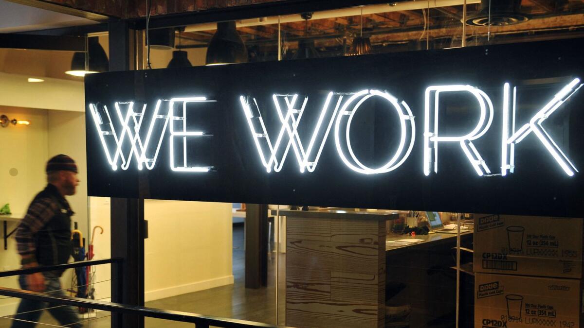A man enters the 'WeWork' co-operative co-working space in Washington, DC.  WeWork announced plans to enter public markets through a merger with a special purpose acquisition company in a transaction that raises $1.3 billion for the office-sharing firm. — AFP file