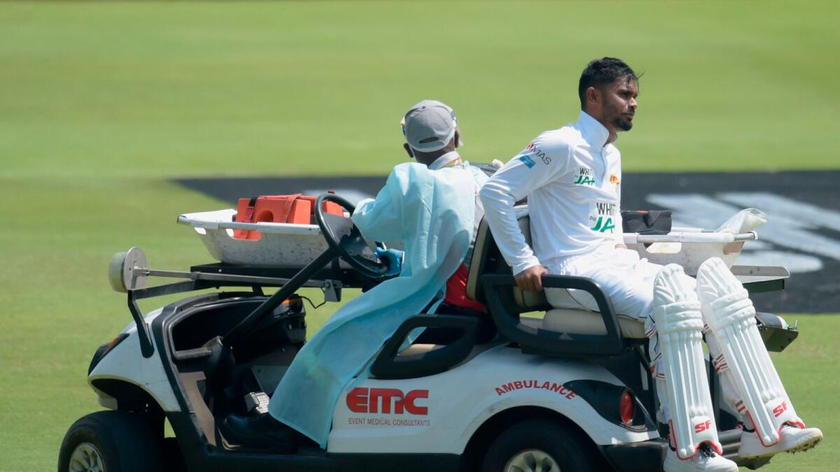Sri Lanka's Dhananjaya de Silva is helped off the field by medical staff after being injured during the first day of the first Test.— AFP