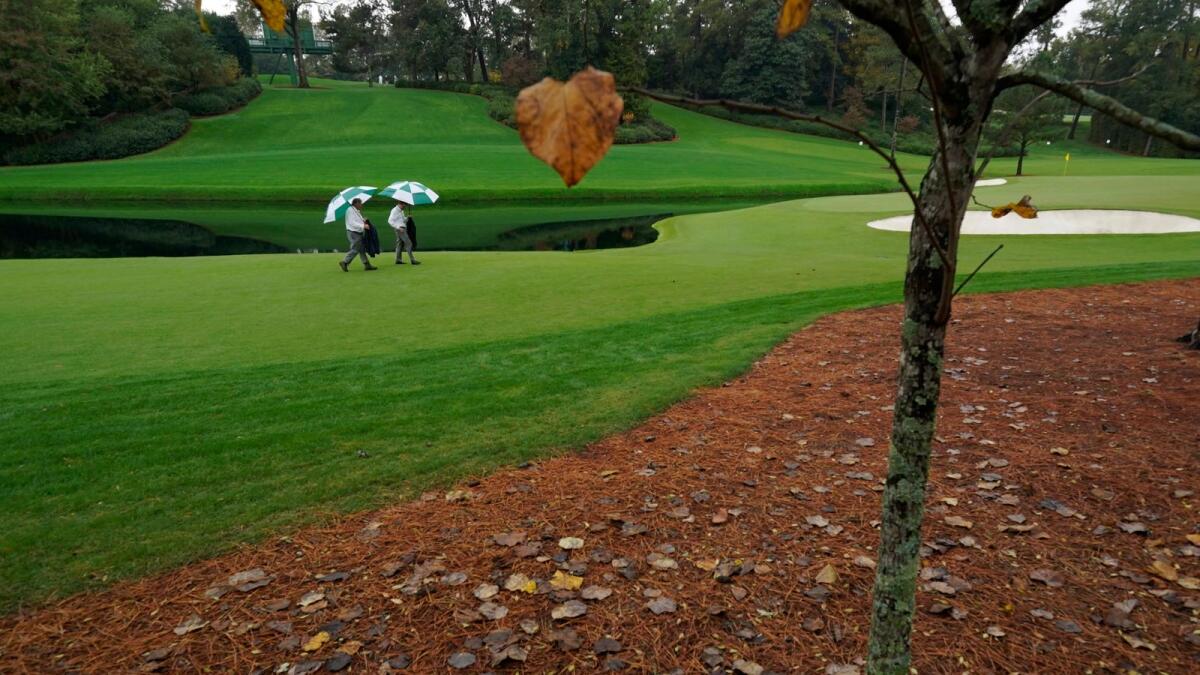 Course marshalls walk along the 16th fairway during a practice round for the Masters. — AP