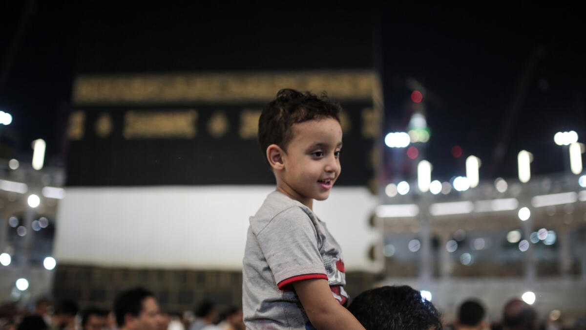 In this Monday, Sept. 21, 2015 photo, a Muslim pilgrim carries his son as they circle the Kaaba, the cubic building at the Grand Mosque in the Muslim holy city of Makkah. (AP Photo)