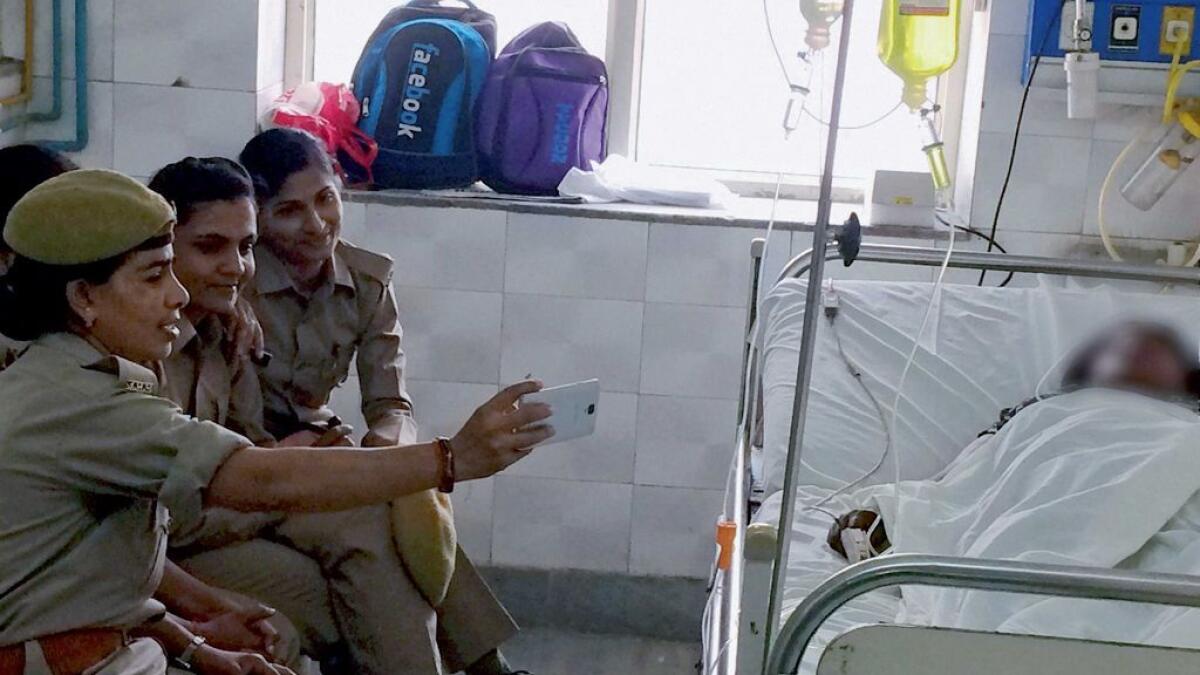 Woman constables posted for the security of gang rape and acid attack survivor, taking selfies in KGMU, Lucknow, on Friday. 