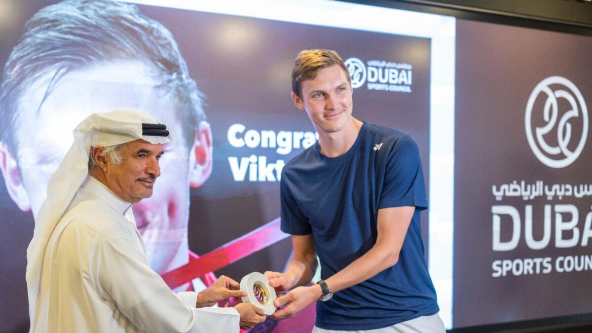 Denmark's Viktor Axelsen, Olympic men's singles badminton champion, receives a memento from Saeed Hareb, Secretary General of Dubai Sports Council, on Monday. (Photo by Shihab)