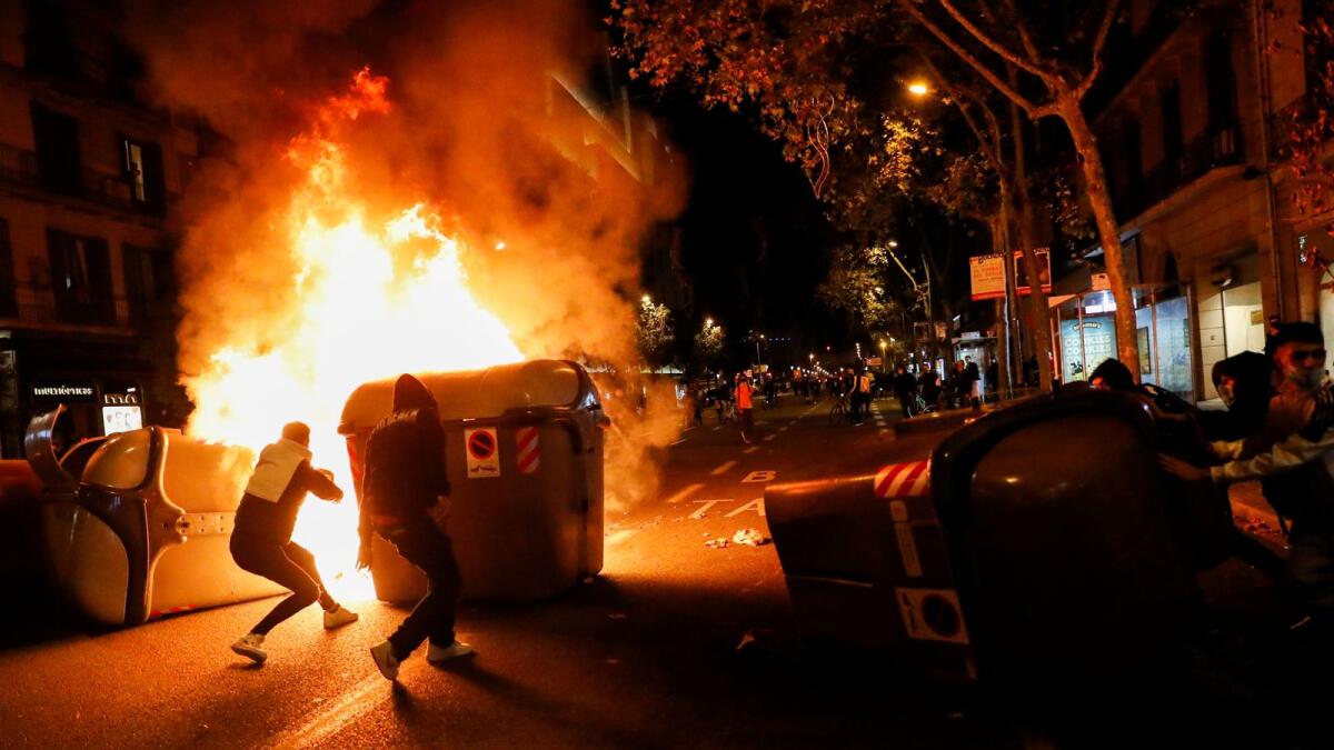Demonstrators stand behind a burning barricade during a protest against the closure of bars and gyms, amidst the coronavirus disease (COVID-19) outbreak, in Barcelona, Spain October 30, 2020.