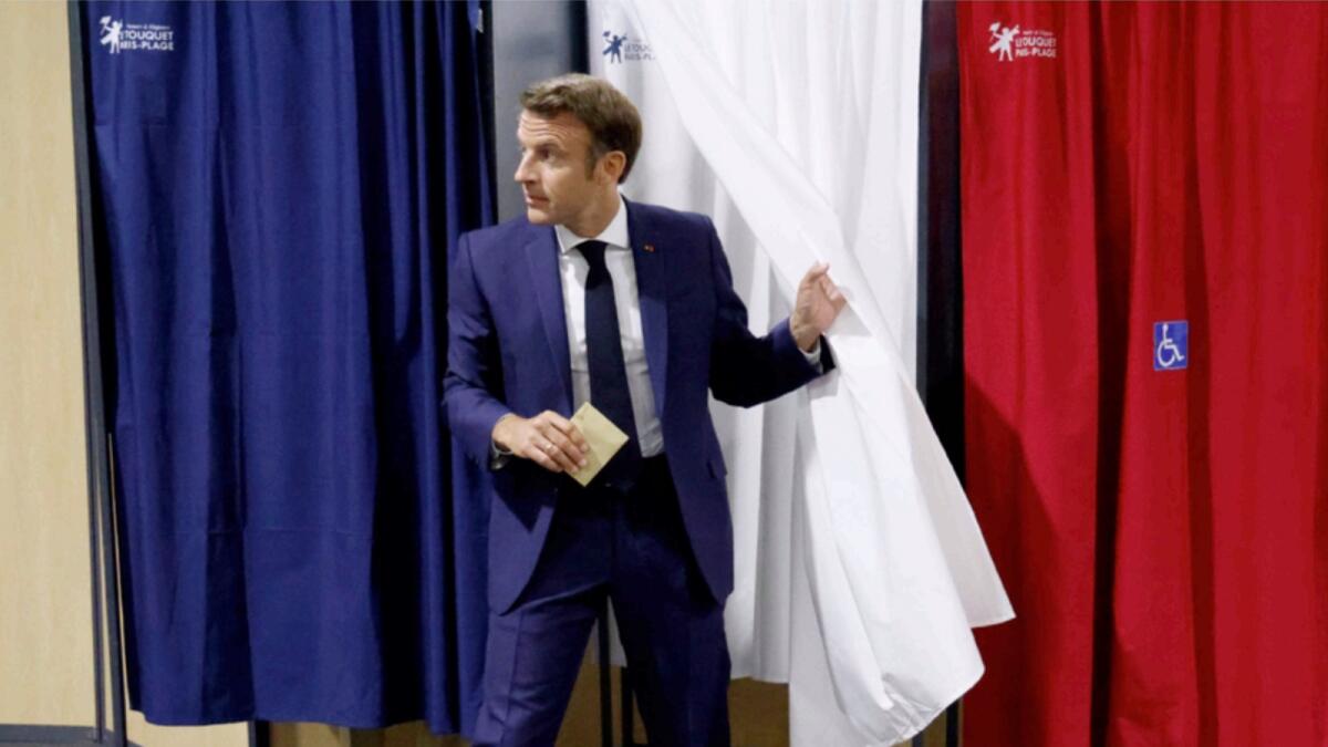 France's President Emmanuel Macron leaves the voting booth before voting in the first round of French parliamentary election at a polling station in Le Touquet, northern France. — AP