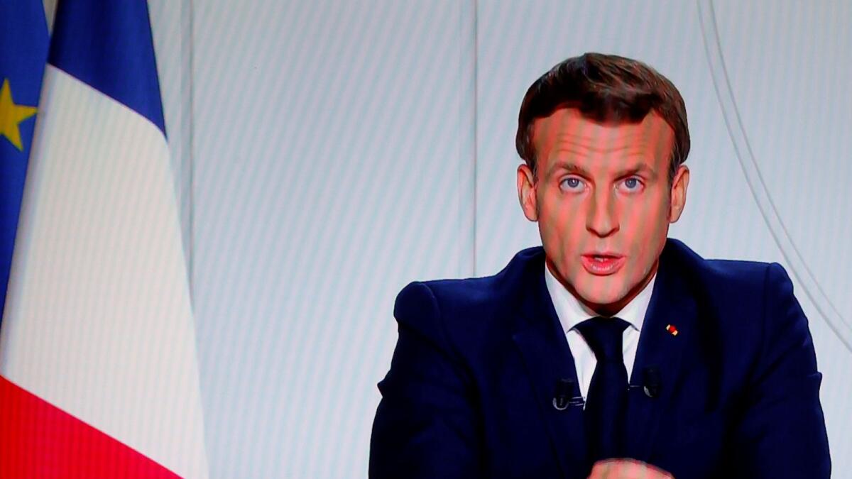 French President Emmanuel Macron is seen on a screen as he addresses the nation about the state of the coronavirus disease (COVID-19) outbreak in France in this illustration picture, October 28, 2020.