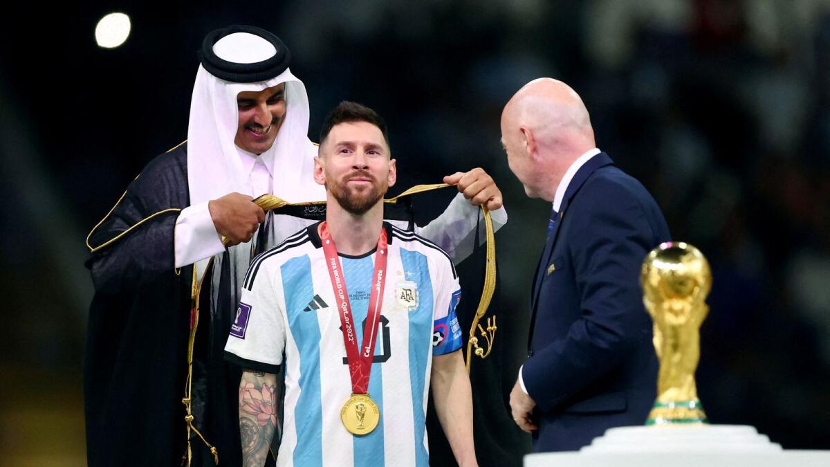 Argentina's Lionel Messi, Emir of Qatar Sheikh Tamim bin Hamad Al Thani and FIFA president Gianni Infantino during the trophy ceremony. Photo: Reuters