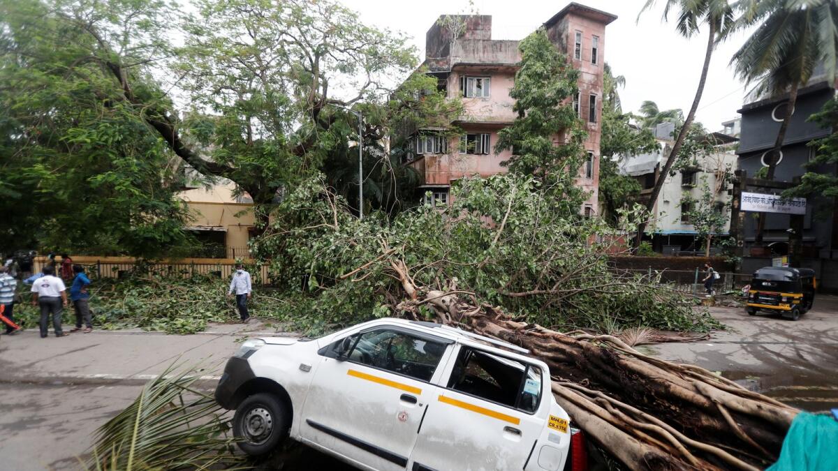 An uprooted tree is seen fallen on a car after strong winds caused by Cyclone Tauktae, in Mumbai, India, May 18, 2021.