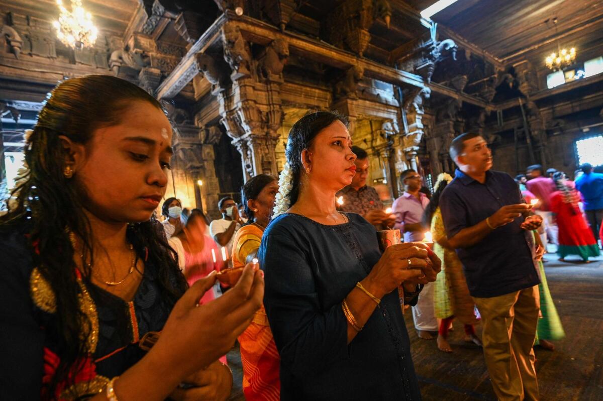 Devotees light oil lamps while offering prayers during New Year's Day at a Hindu temple in Colombo on January 1, 2024. — AFP file