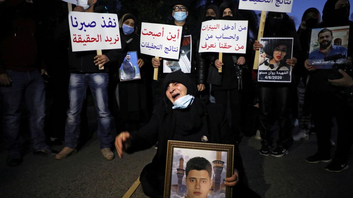 Families of some of the victims of the August 4 explosion at Beirut port, carry their pictures and signs during a protest outside the Justice Palace in Beirut, Lebanon, on Friday.