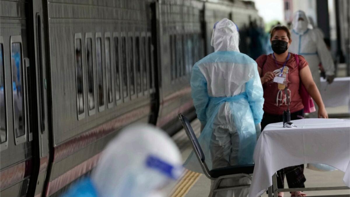 A health worker talks with a woman, who is among a group of people infected with Covid-19, as she arrived at Rangsit train station in Pathum Thani Province, Thailand. Thai authorities began transporting some people who have tested positive with the coronavirus from Bangkok to their hometowns for isolation and treatment.— AP