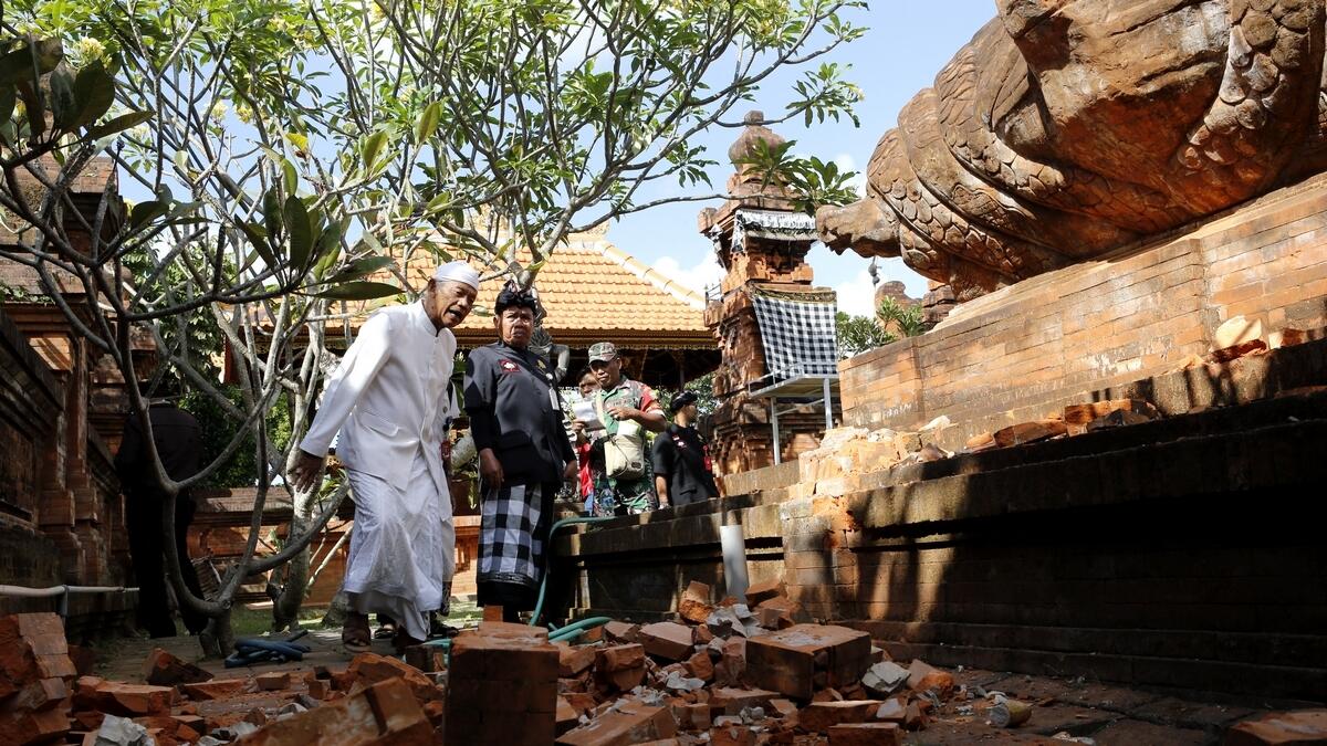 Balinese men check a damaged temple in Bali, Indonesia.