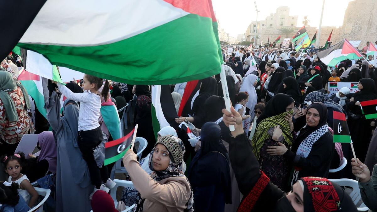 Libyans chant slogans and wave Palestinian and Libyan national flags as they march in solidarity with the people of Palestine in Martyr's Square in the capital Tripoli. — AFP
