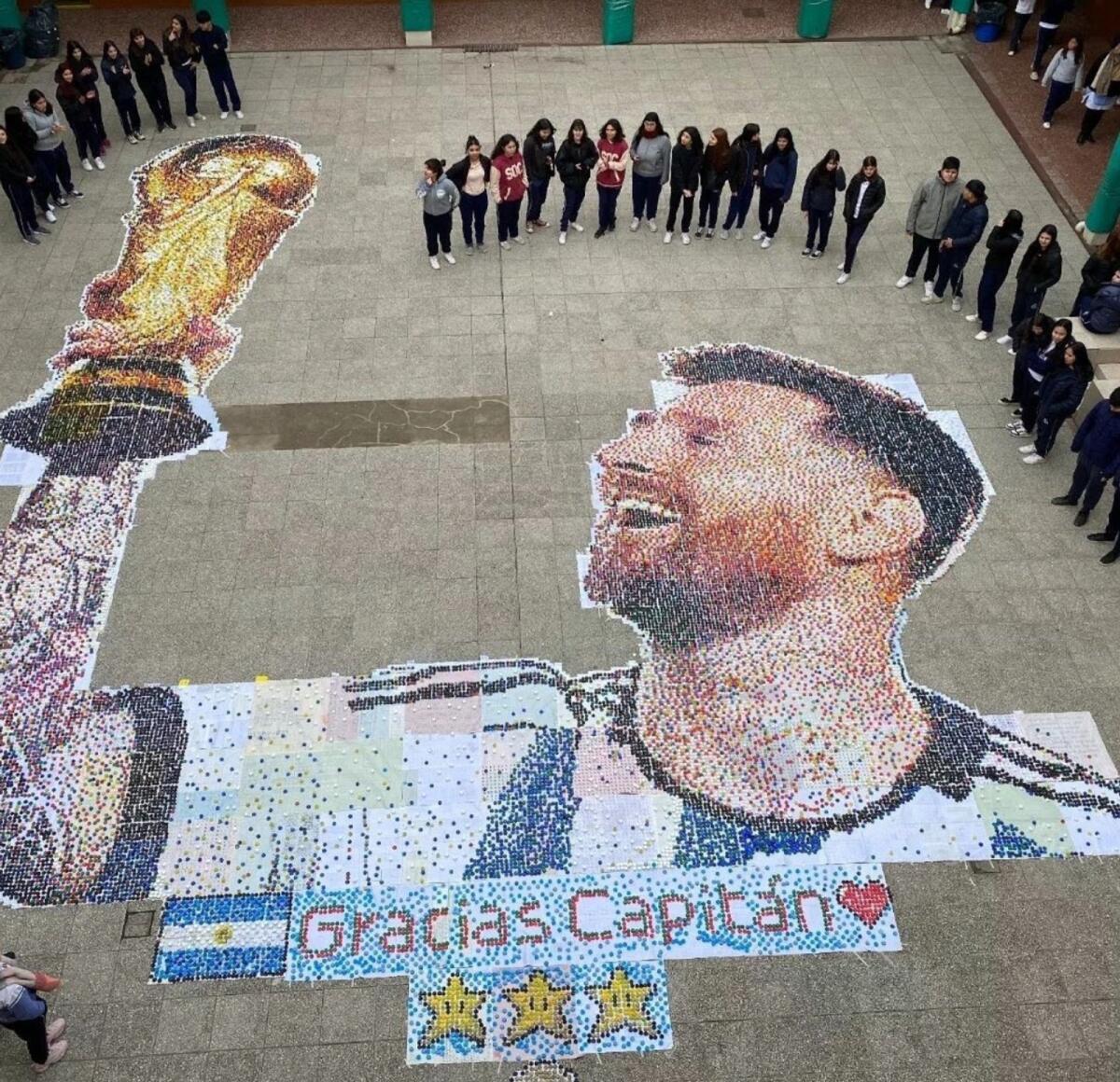 Students pose in front of the Lionel Messi mural. — X