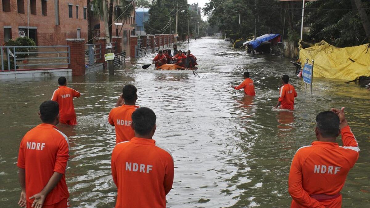 Indias National Disaster Response Force (NDRF) personnel conduct a rescue operation through a flooded road in Chennai, in the southern state of Tamil Nadu, India.  