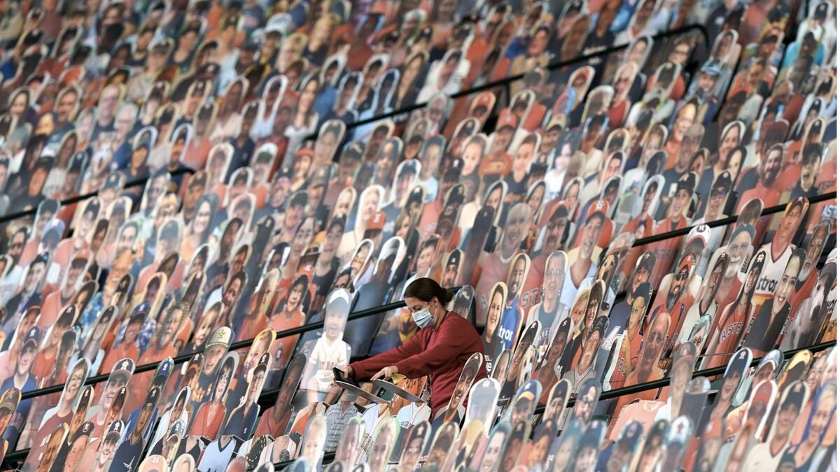 Cutouts of fans in the stands of Minute Maid Park are adjusted before a baseball game between the Texas Rangers and Houston Astros, in Houston. Photo: AP