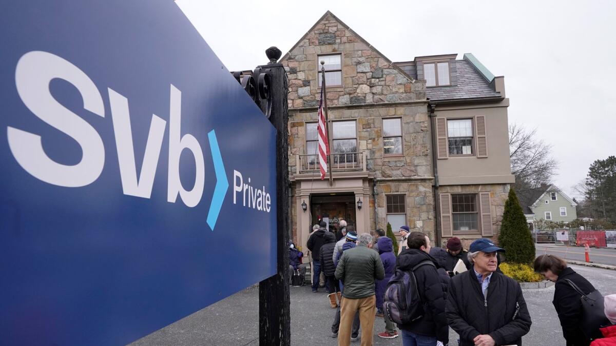 Customers and bystanders form a line outside a Silicon Valley Bank branch in Wellesley, Massachusetts. - AP