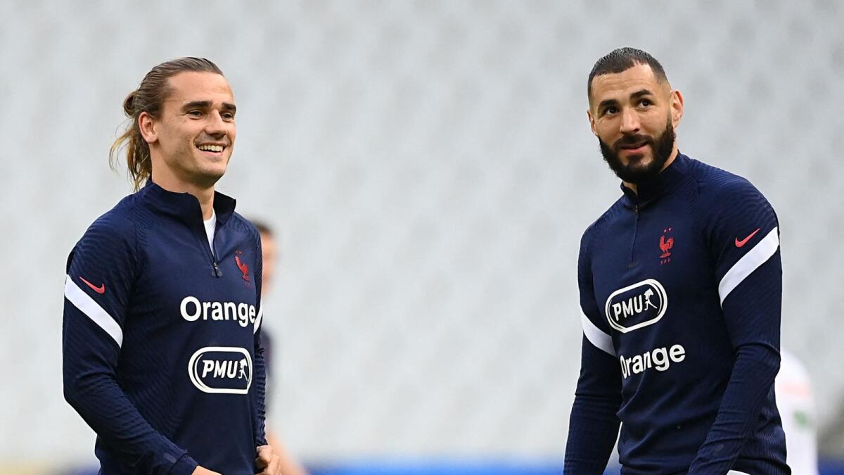 France's forwards Antoine Griezmann (L) and Karim Benzema (R) warm up before a friendly football match between France and Bulgaria in Saint-Denis, Paris. Photo: AFP