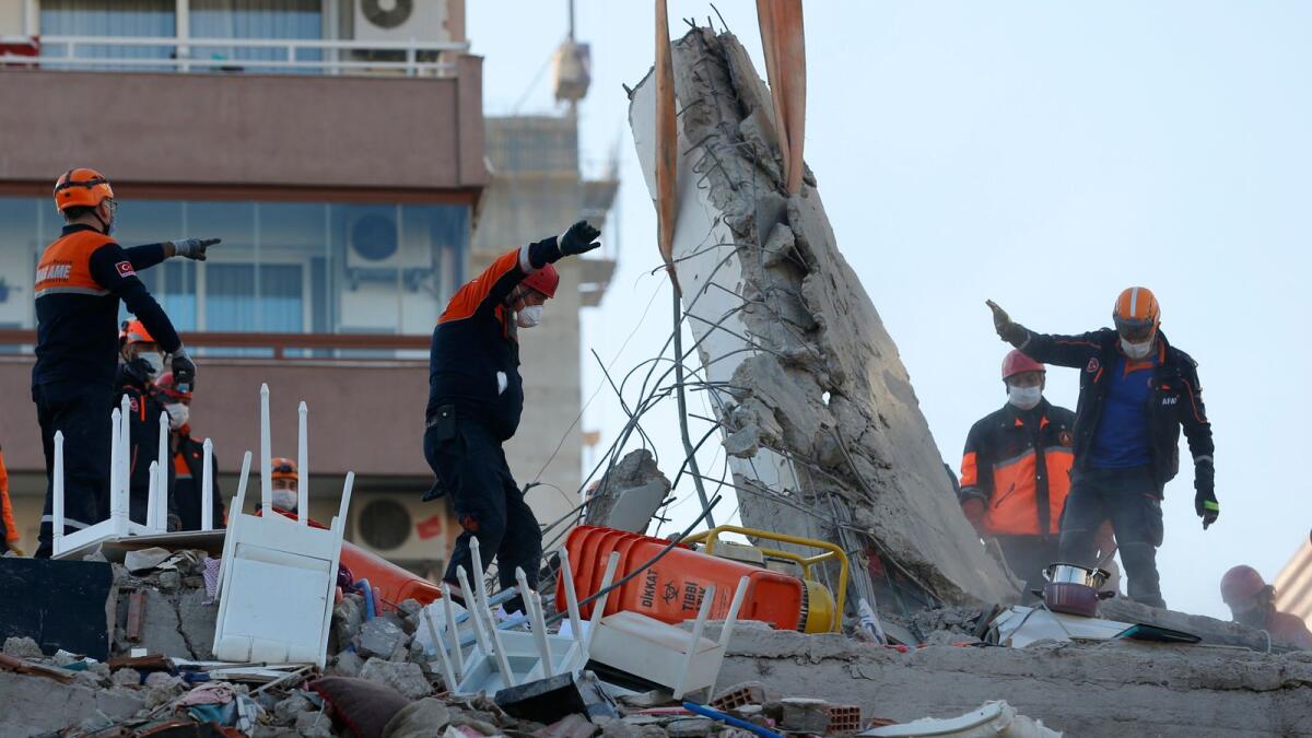 Members of rescue services search for survivors in the debris of a collapsed building in Izmir, Turkey. AP