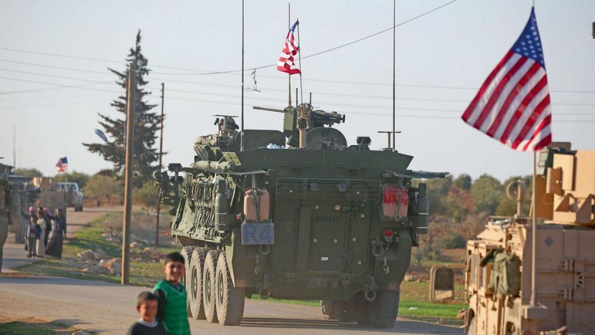 A convoy of US armoured vehicles drives near the village of Yalanli, on the western outskirts of Manbij, a Syiran city. 