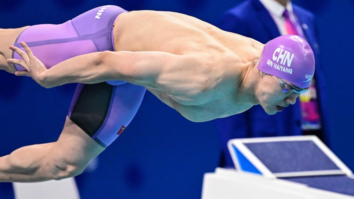 China's Qin Haiyang dives at the start of the final of the men's 50m breaststroke swimming event which he won. - AFP