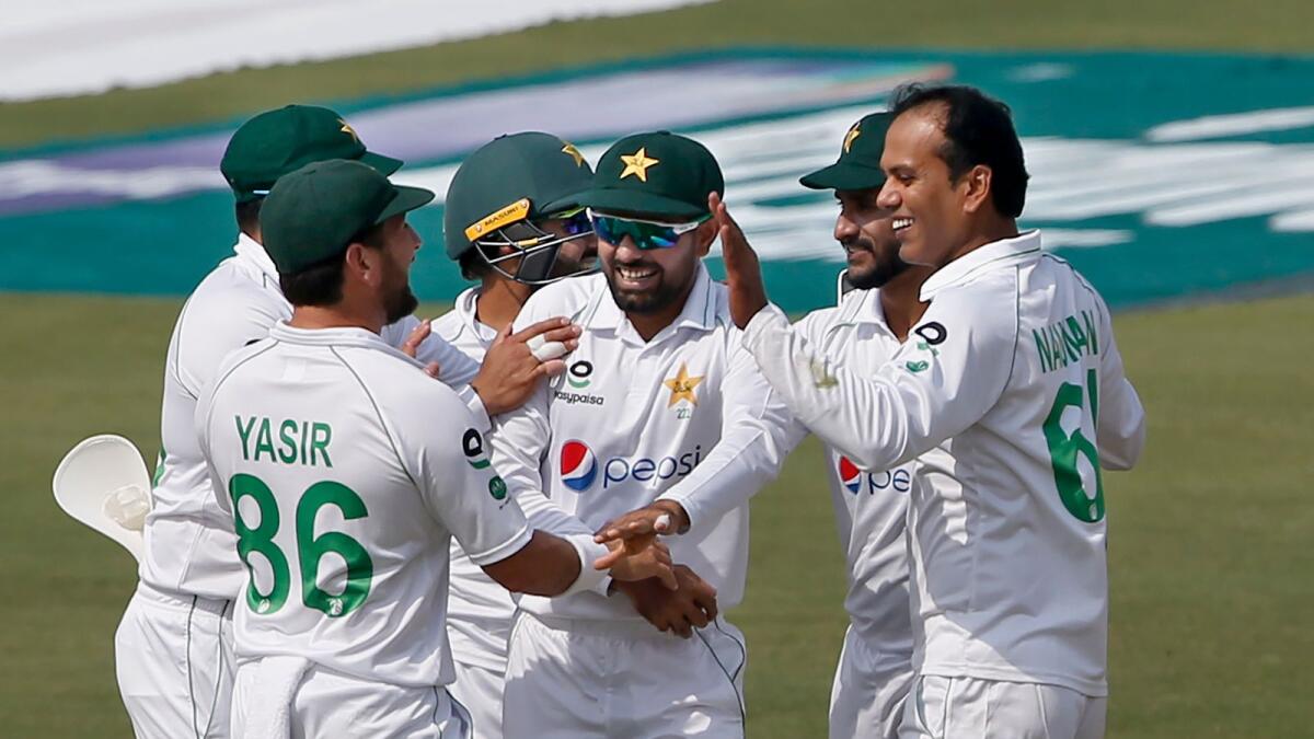 Pakistan's Nauman Ali (right) celebrates with teammates after taking the wicket of South Africa's batsman Dean Elgar. (AP)