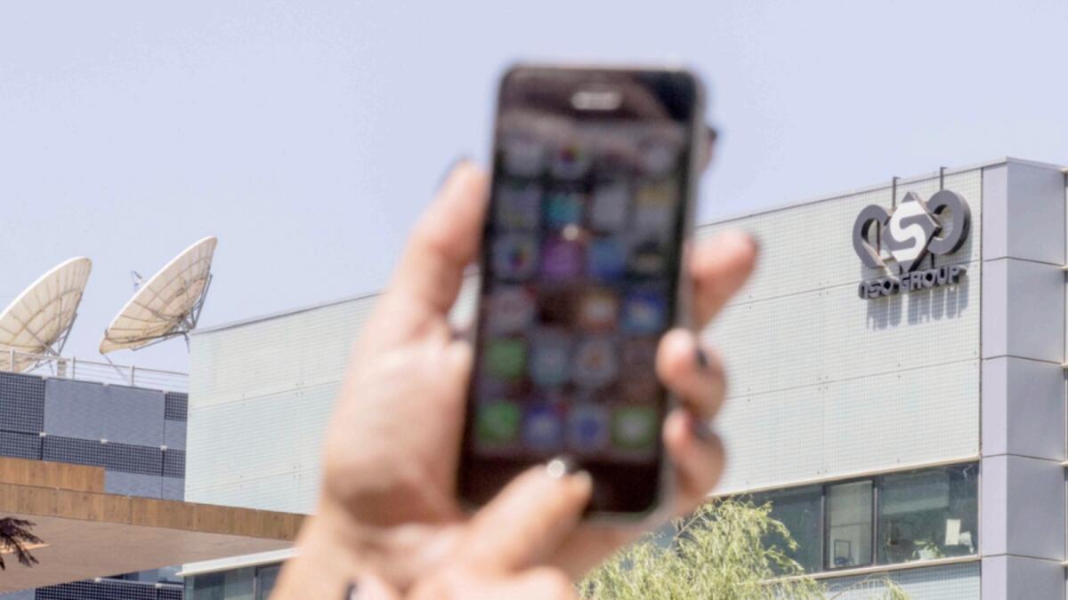 A woman uses her iPhone in front of the building housing the Israeli NSO group Pegasus, in Herzliya, near Tel Aviv. — AFP