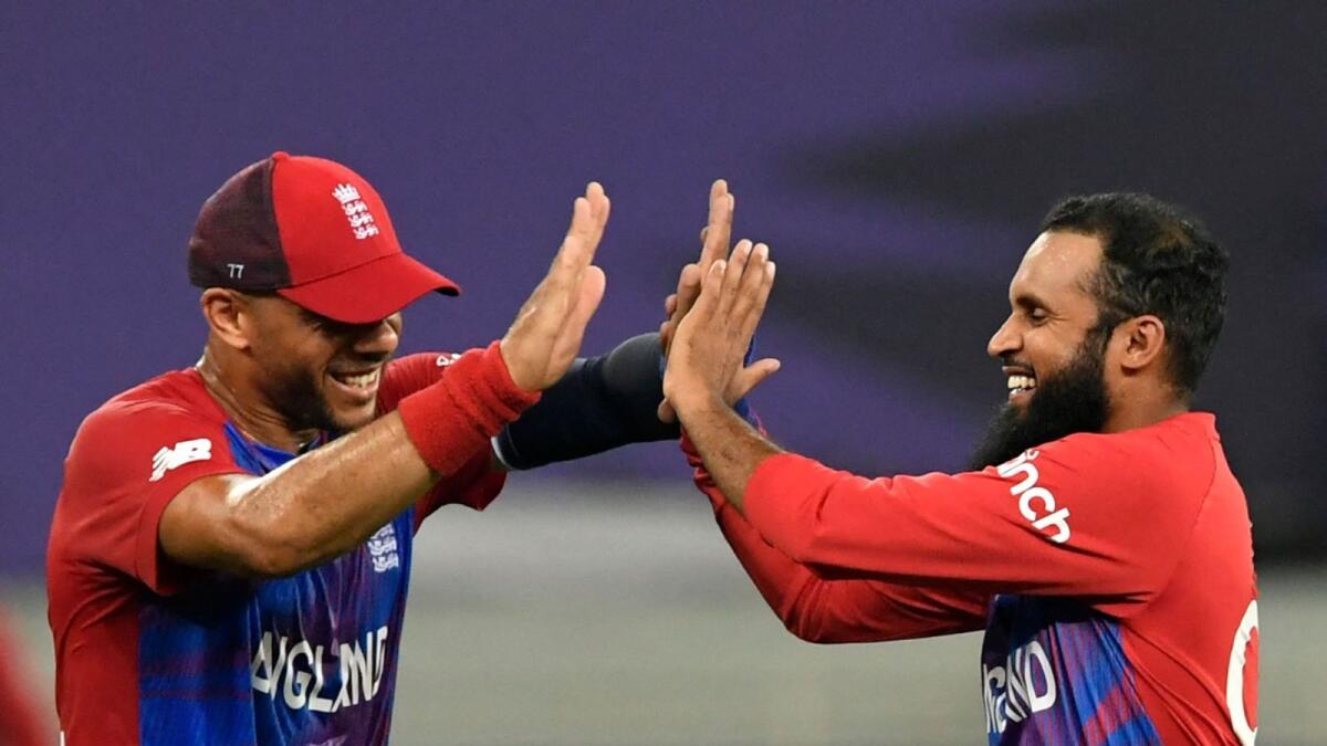 England's Adil Rashid (right) celebrates with teammate Tymal Mills after taking the wicket of West Indies' Obed McCoy. (AFP)
