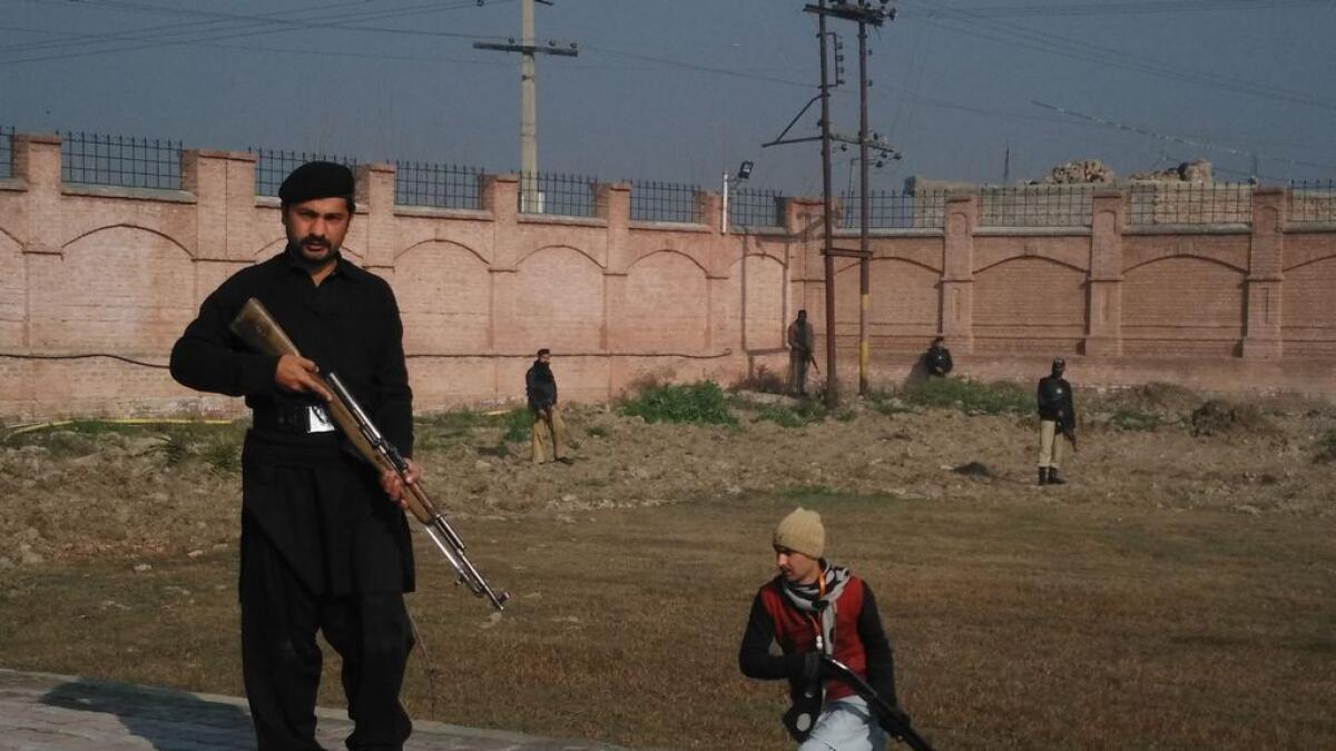 This photograph taken from a mobile phone shows Pakistani security personnel taking position outside the Bacha Khan university following an attack by gunmen in Charsadda, about 50 kilometres from Peshawar, on January 20, 2016.