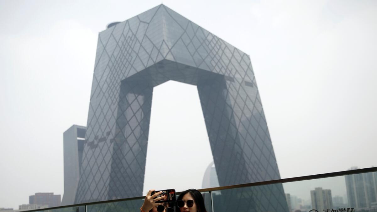 Women pose for pictures at a shopping mall near the CCTV headquarters in Beijing's central business district (CBD), China. Photo: Reuters