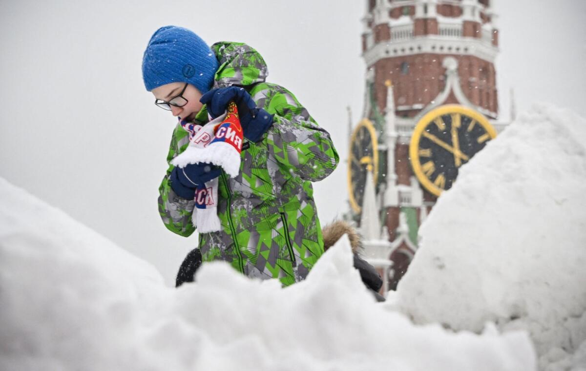A boy plays atop of a snow hill at Red Square in front of the Kremlin's Spasskaya tower after a heavy snowfall in Moscow on December 4, 2023.  Photos: AFP