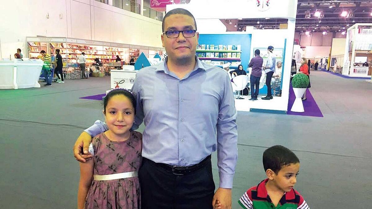 Ahmed Abdullah and his children during the Sharjah Reading Festival being held in the Expo Centre.— Photo by M. Sajjad