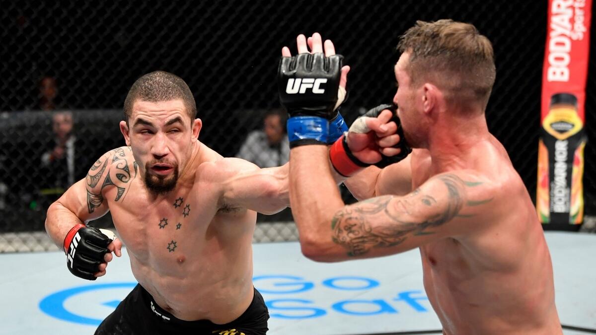 Robert Whittaker of New Zealand punches Darren Till of England in their middleweight championship fight. (AFP)