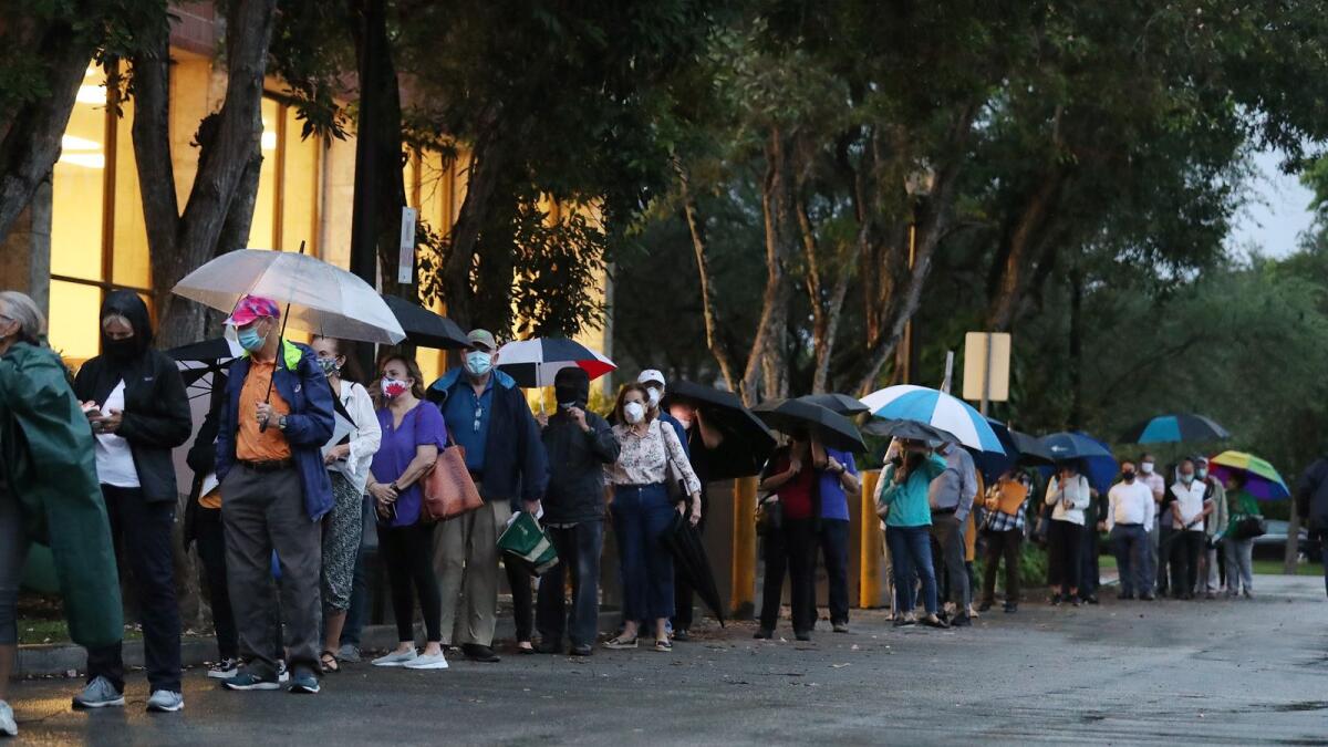 Voters wait in line to cast their early ballots at the Coral Gables Branch Library precinct in Coral Gables, Florida, on Monday.