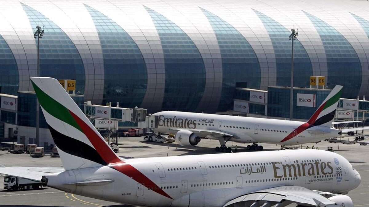 Emirates passenger planes parked at their gates at Dubai airport.