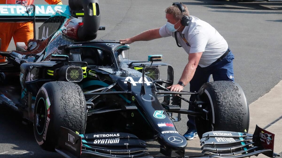 Engineers move Mercedes' British driver Lewis Hamilton's car with blisters on the tyres after the F1 70th Anniversary Grand Prix at Silverstone