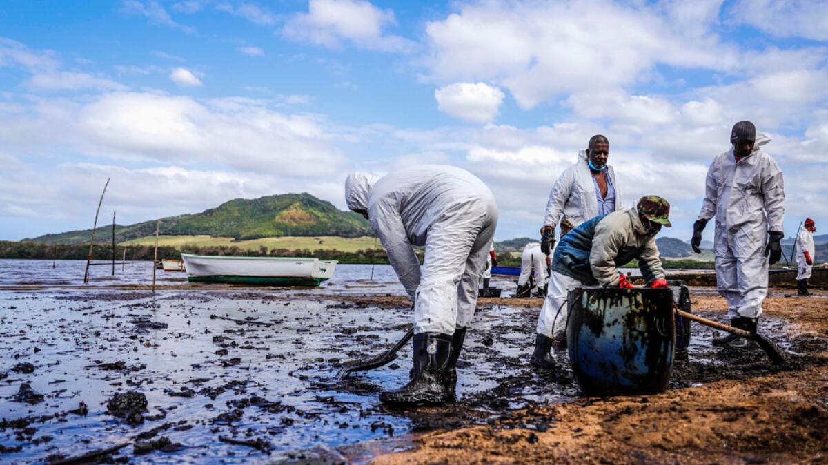 People scoop leaked oil from the vessel MV Wakashio, belonging to a Japanese company but Panamanian-flagged, that ran aground and caused oil leakage near Blue bay Marine Park in southeast Mauritius on August 9, 2020. Photo: AFP