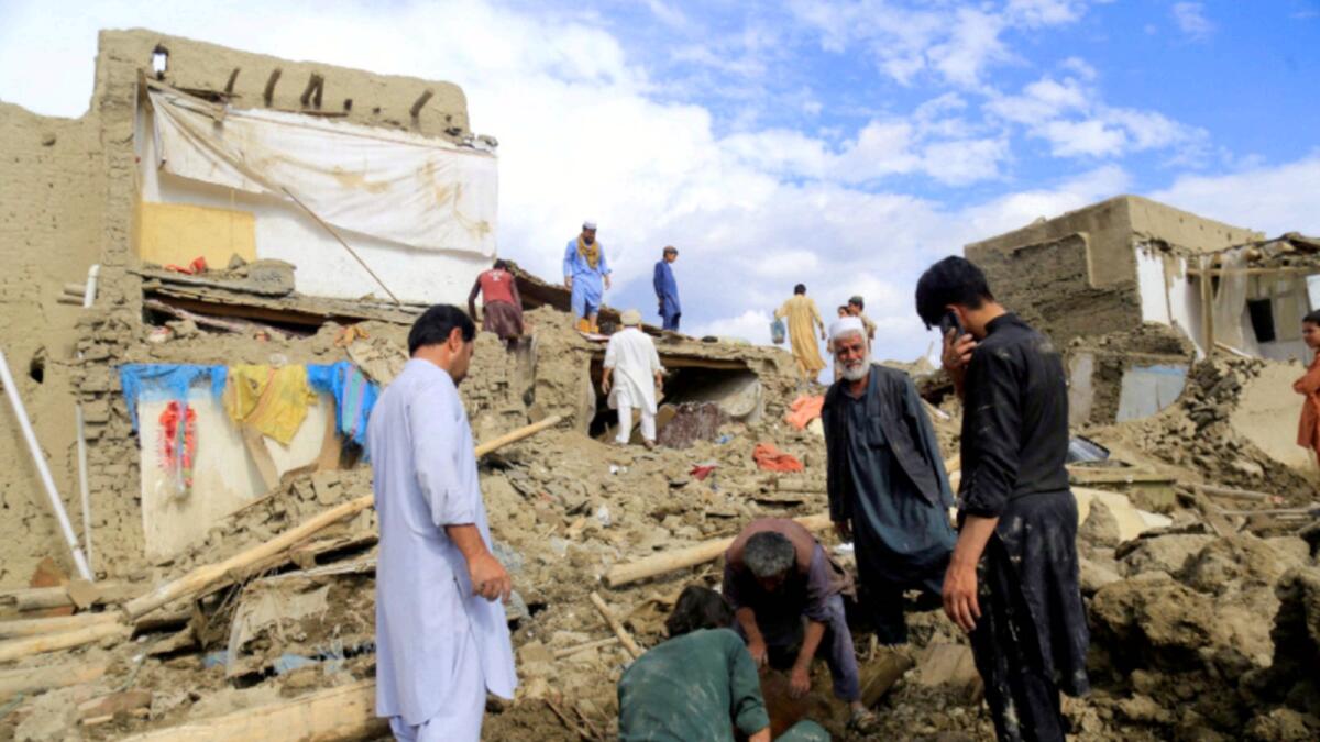 People clean up their damaged homes after the heavy flood in the Khushi district of Logar. — Reuters