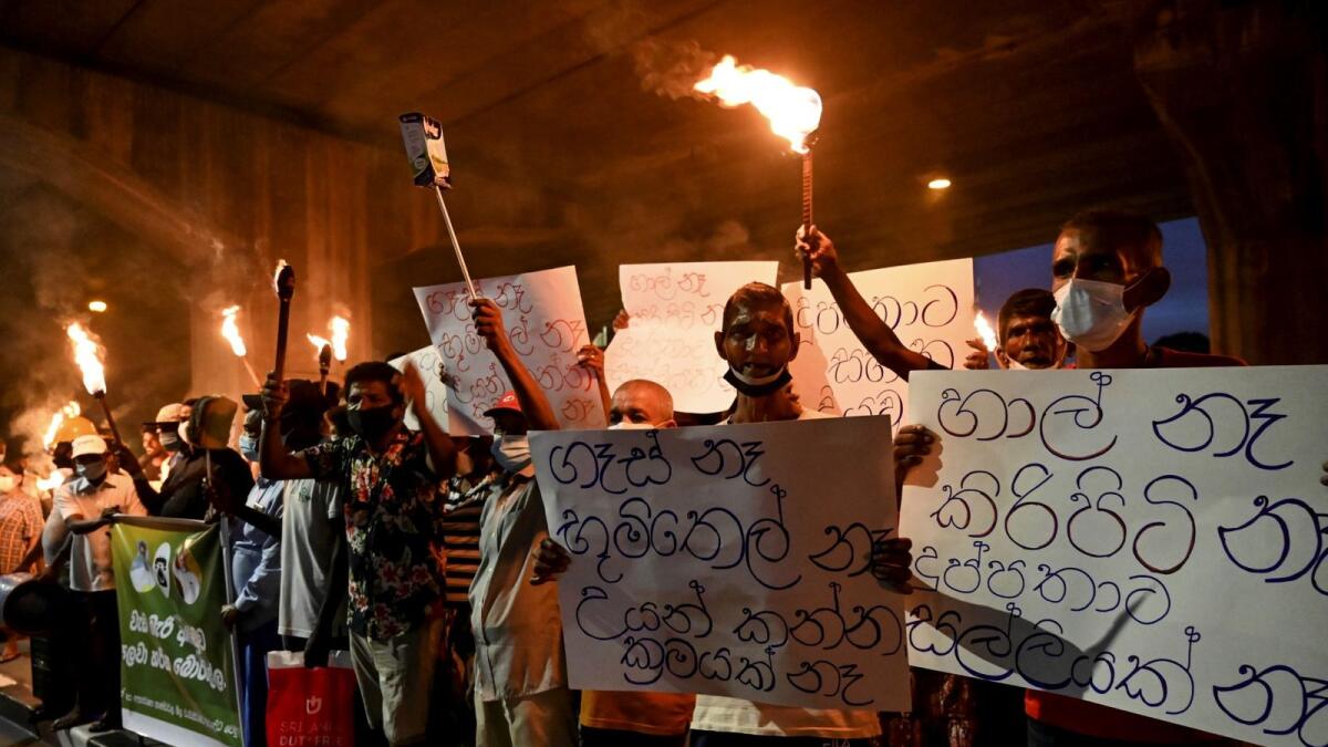 Sri Lanka's opposition activists hold torches during a demonstration to denounce the shortage of cooking gas, kerosene oil and a few other commodities. — AFP file