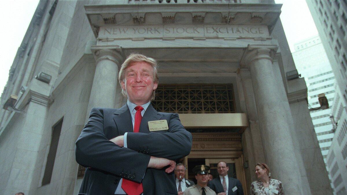 Donald Trump poses for photos outside the New York Stock Exchange after the listing of his stock on Wed., June 7, 1995 in New York. AP