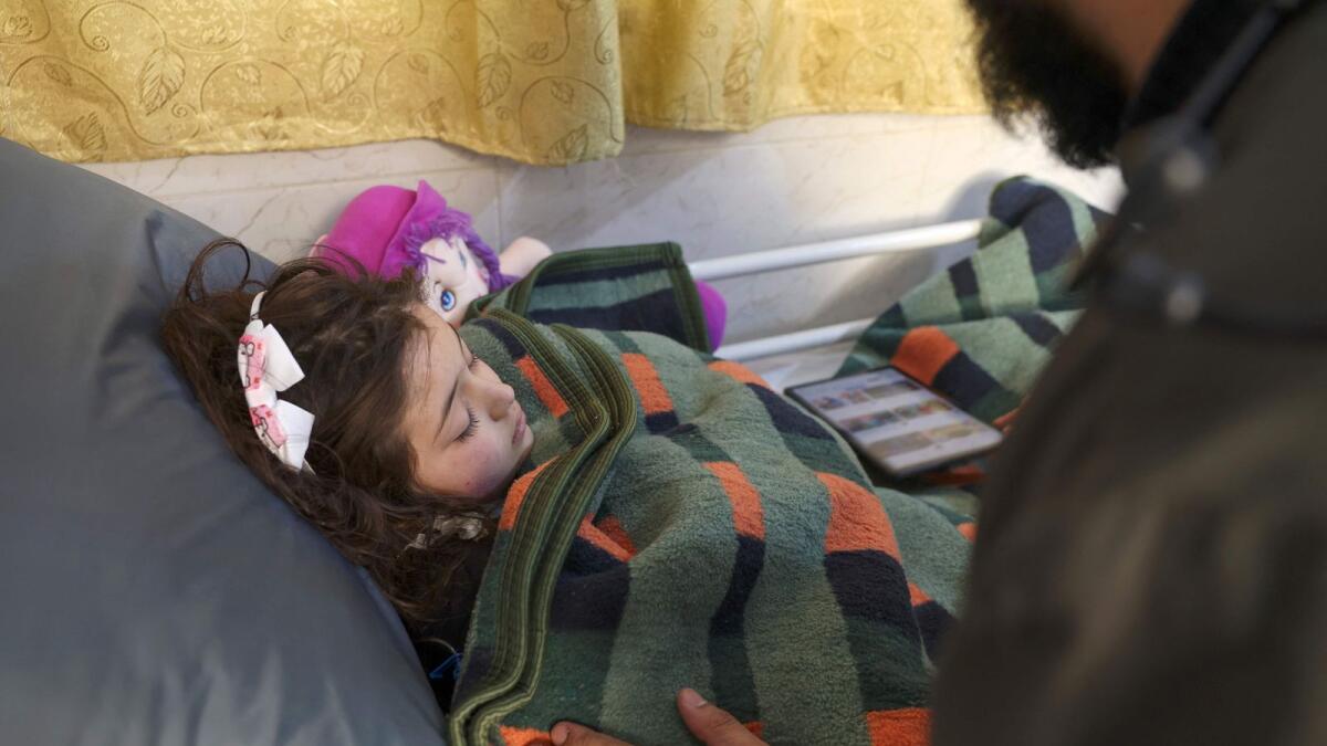 Syrian girl Sham Sheikh Mohammad, 9, who was rescued after fourty hours under the rubble of a deadly earthquake, lies on a hospital bed in the rebel-held northwestern city of Idlib, on February 17, 2023. — AFP